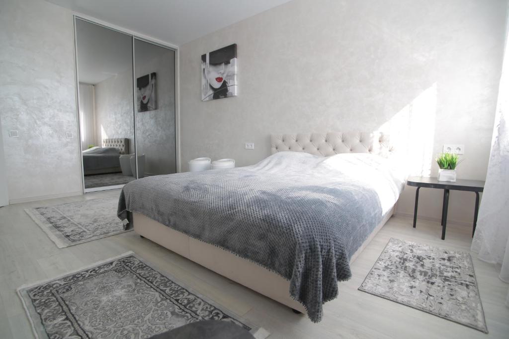 um quarto com uma cama grande e um espelho em Ніжність em Rivne