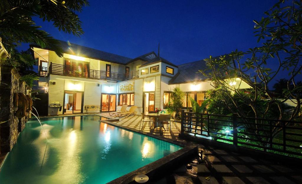 una piscina frente a una casa por la noche en Samui Sun Villa en Chaweng Beach