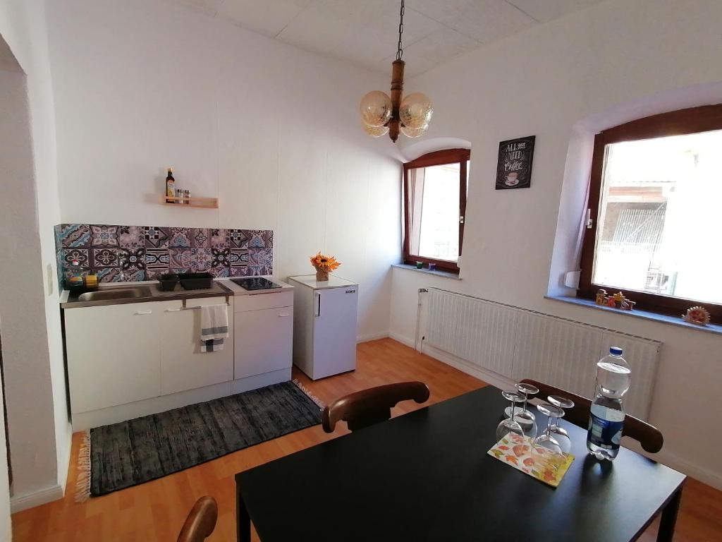 een woonkamer met een tafel en een keuken bij Klein aber fein! in Emskirchen