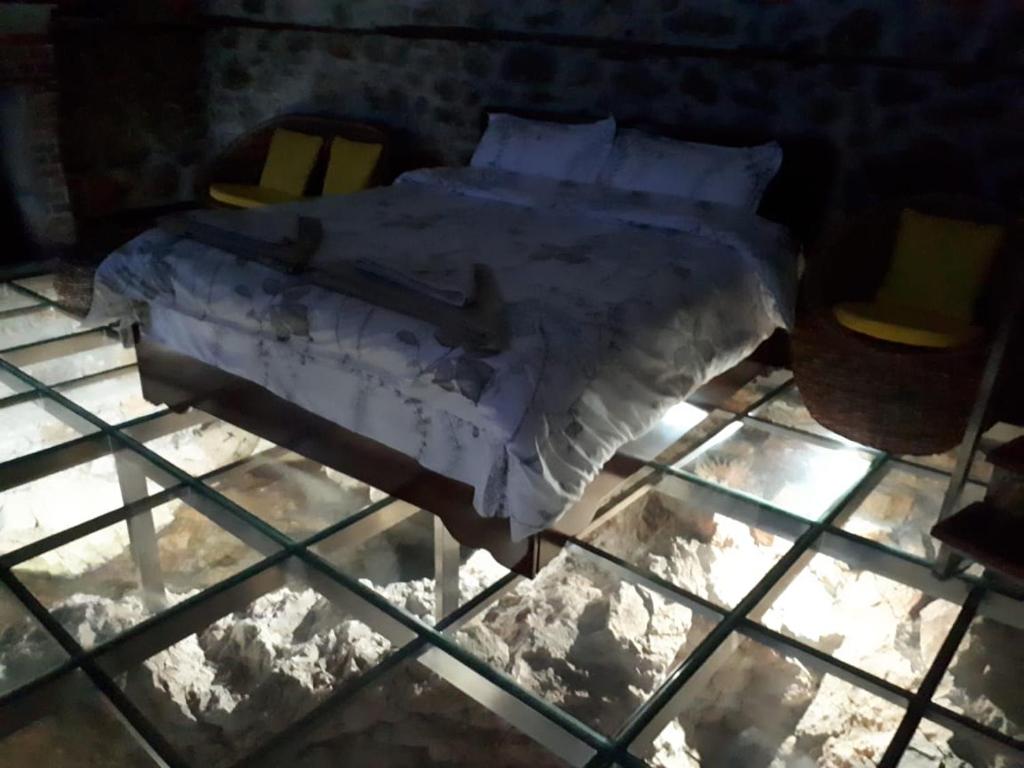 uma cama num quarto com neve no chão em Nuci's Home glass floor em Tushemisht