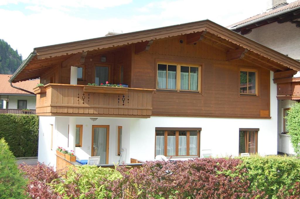 a house with a balcony on top of it at Landhaus Alpenrose in Mayrhofen