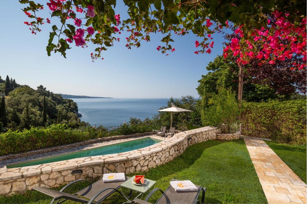 a backyard with a pool and a view of the ocean at Kalami Beach - Villa Almyra in Kalami