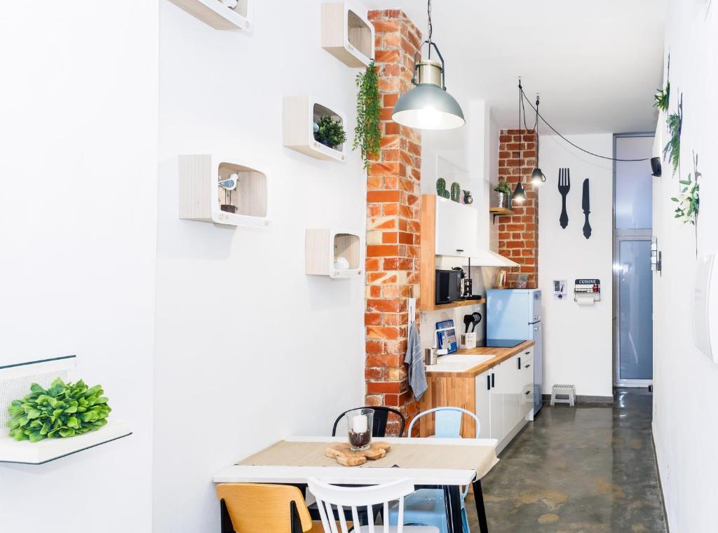 a kitchen with a brick wall and a table and chairs at Maná Loft Apartamento original en el centro de Alicante in Alicante