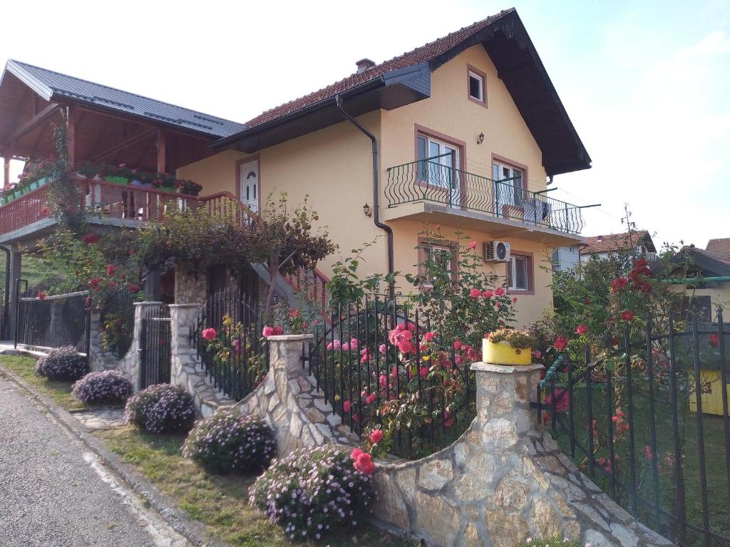 a house with a fence and flowers in front of it at Apartman" Ruža" in Višegrad