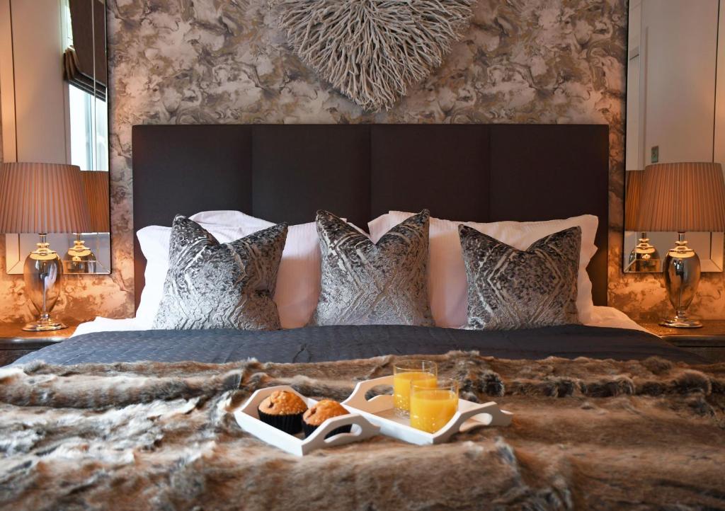 a bed with a tray of food on it at Gleneagles Luxury Apartment in Auchterarder