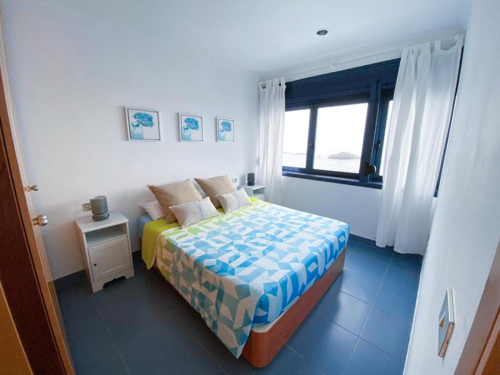 een slaapkamer met een bed en een raam bij Ventana al roque apartamento con vistas al mar in Santa Cruz de Tenerife