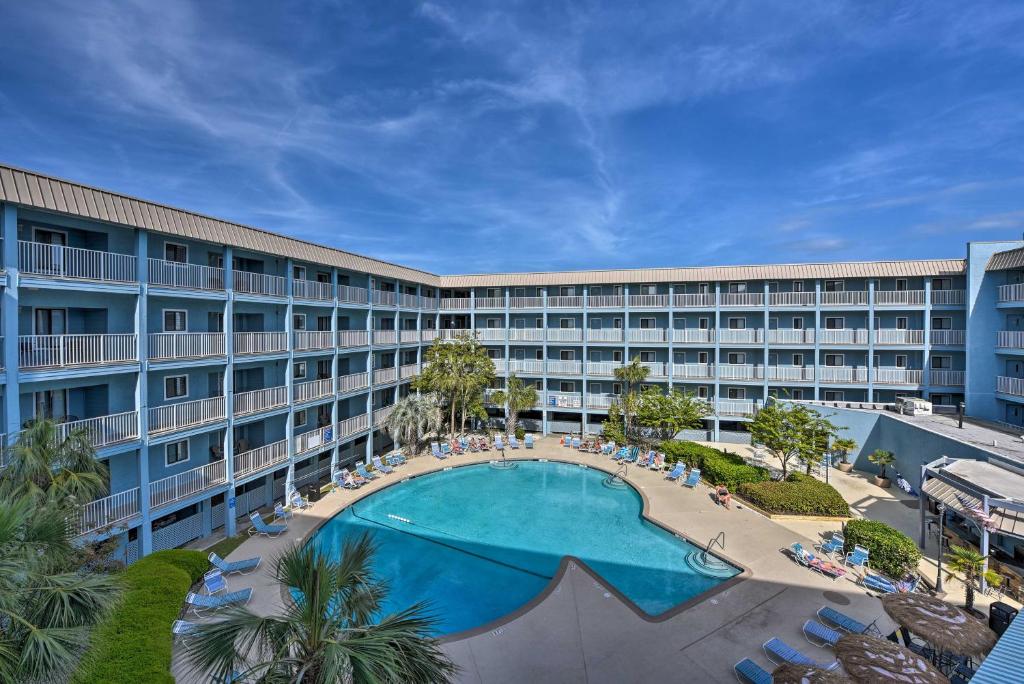 an exterior view of a hotel with a large swimming pool at Walk to Beach Nautical Hilton Head Resort Condo! in Hilton Head Island