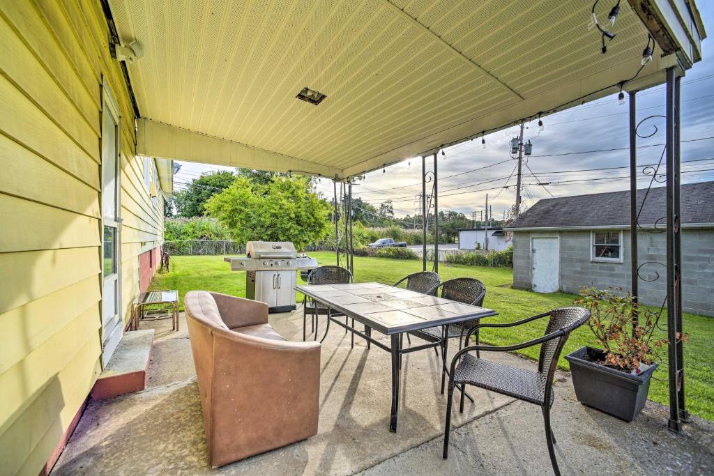 un patio con mesa, sillas y parrilla en Albany Home with Fenced Yard and Patio - Pets Welcome!, en Albany