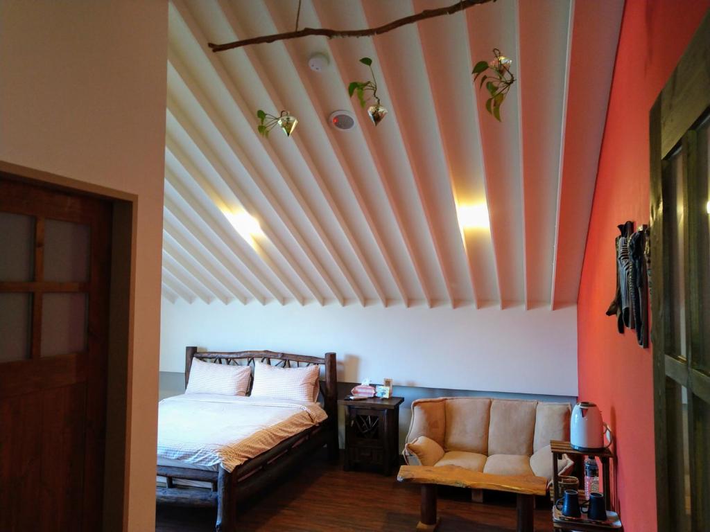 a bedroom with a bed with a wooden ceiling at Celine&#39;s B&amp;B in Fenglin