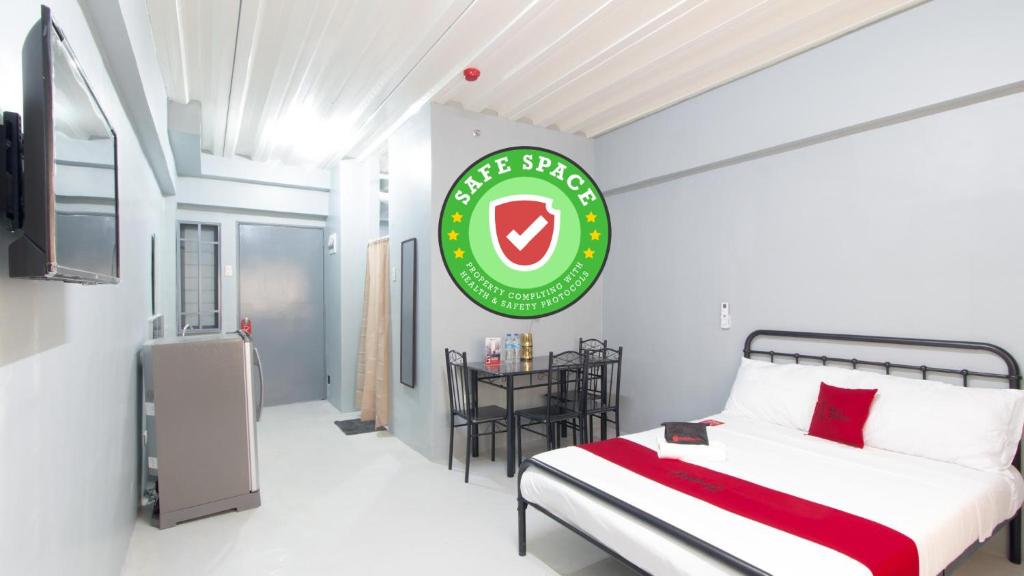 a bedroom with a bed and a green sign on the wall at RedDoorz @ Sunfields Lipa Batangas in Lipa