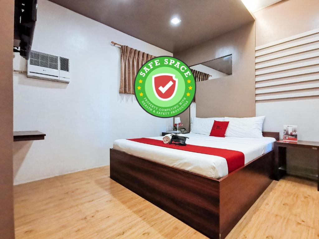 a hotel room with a bed with a sign on it at Reddoorz Plus near Robinsons Place Gensan in General Santos