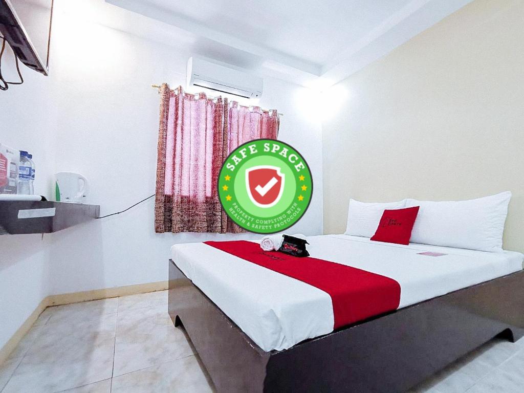 Un dormitorio con una cama con un cartel. en RedDoorz near Notre Dame of Dadiangas University en General Santos