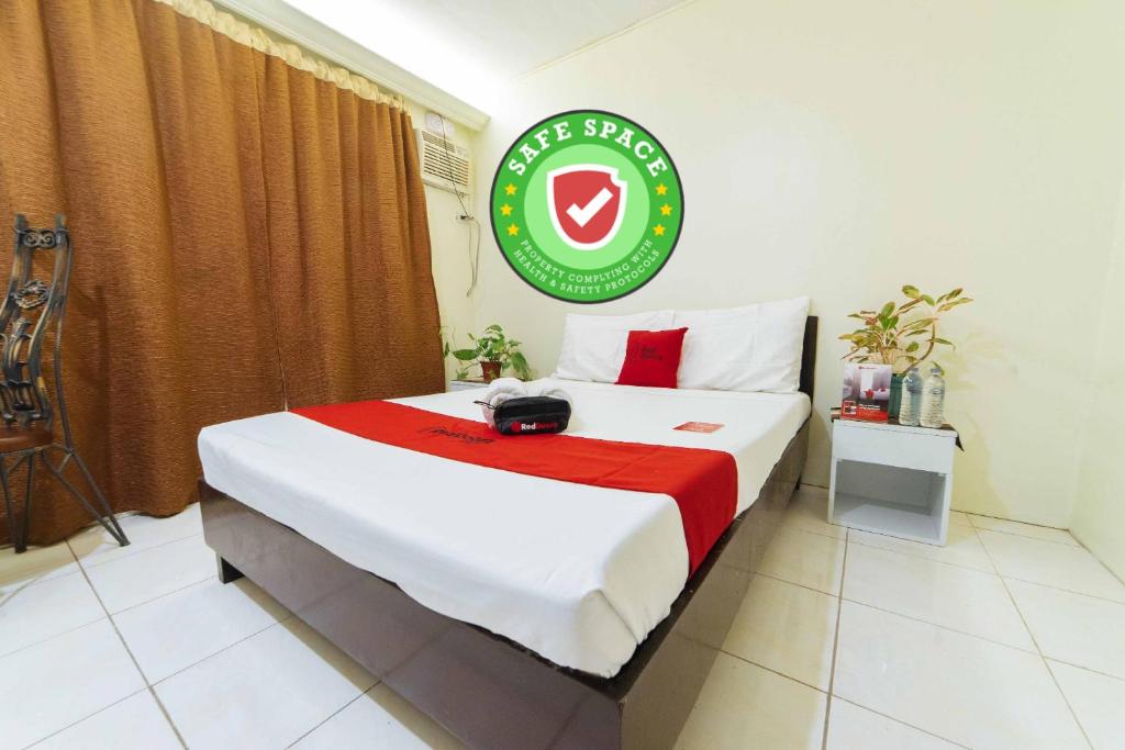 ein Hotelzimmer mit einem Bett mit Schild darauf in der Unterkunft RedDoorz @ Ledesco Avenue Lapaz Iloilo in Iloilo City