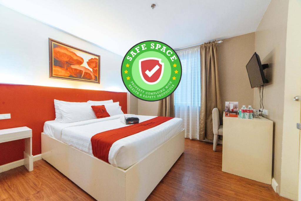a hotel room with a bed with a sign on it at RedDoorz Plus at Hotel Metro Kalibo in Kalibo