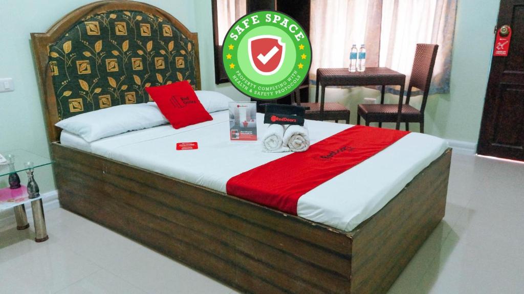 a hotel room with a bed with a sign on it at RedDoorz @ Bankal Lapulapu in Mactan
