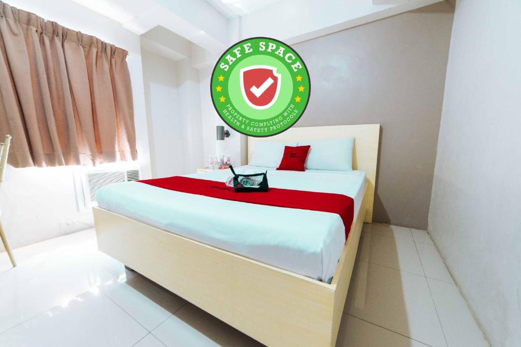 Un dormitorio con una cama con un letrero verde. en RedDoorz at Samat Mandaluyong en Manila