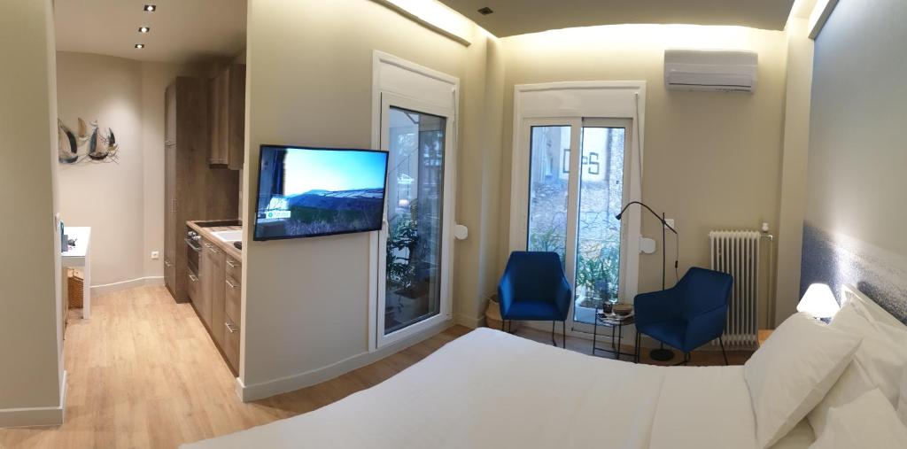 a bedroom with a bed and a flat screen tv at Newly Renovated Studio 15 min walk from Acropolis in Athens