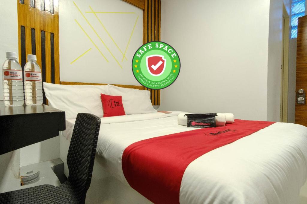 a bedroom with a large bed with a red blanket at RedDoorz near Quiapo Church Manila in Manila