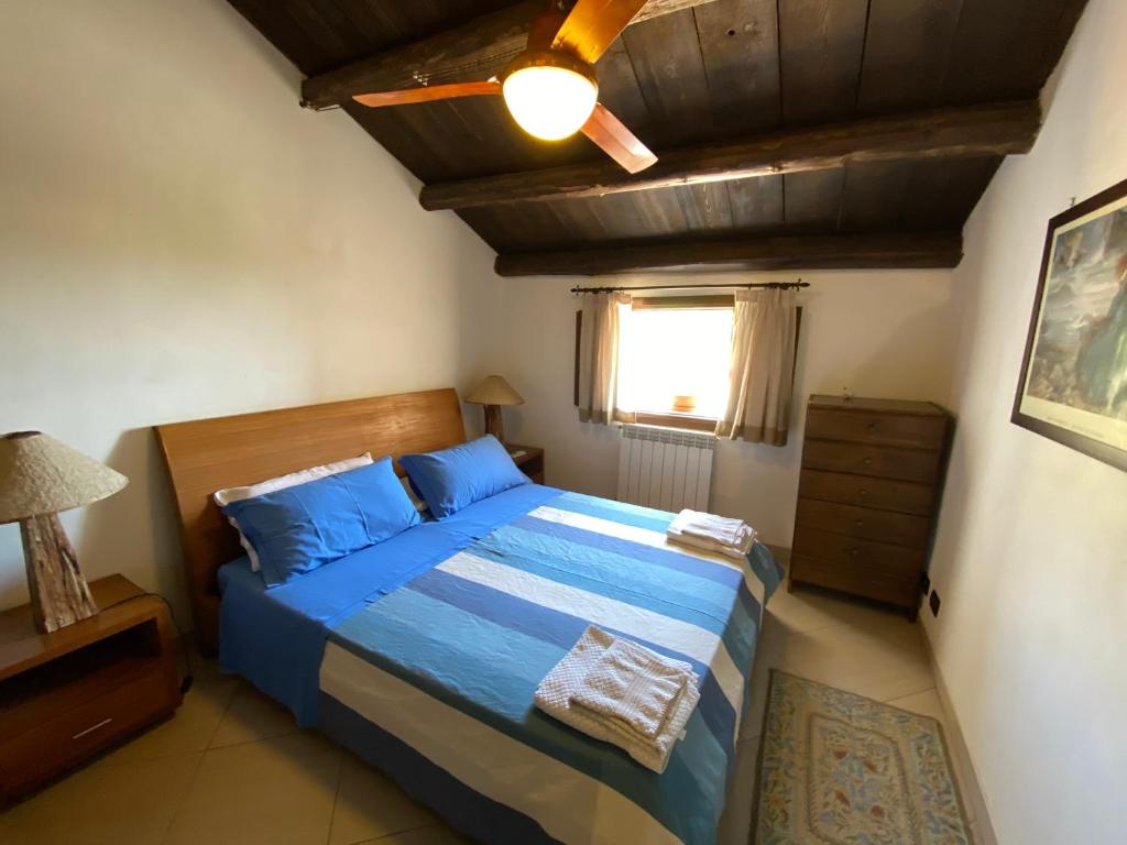 une chambre avec un lit et un ventilateur de plafond dans l'établissement Casale Giulietta, à Scopello