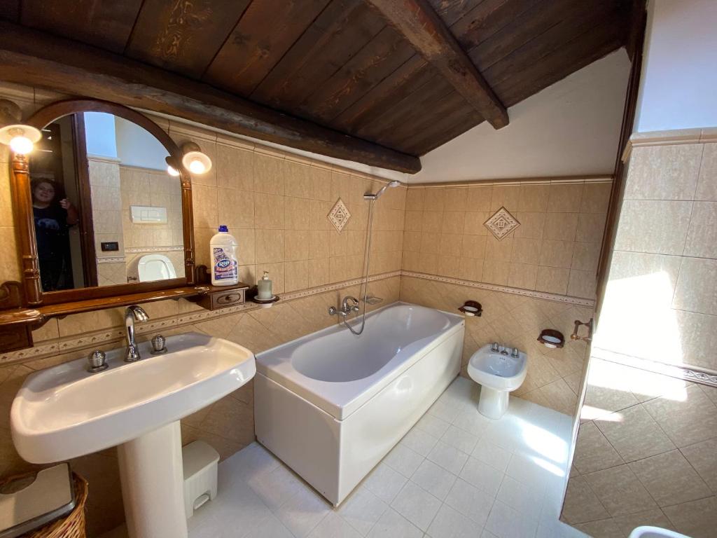 une salle de bain avec une baignoire, un lavabo et des toilettes dans l'établissement Casale Giulietta, à Scopello