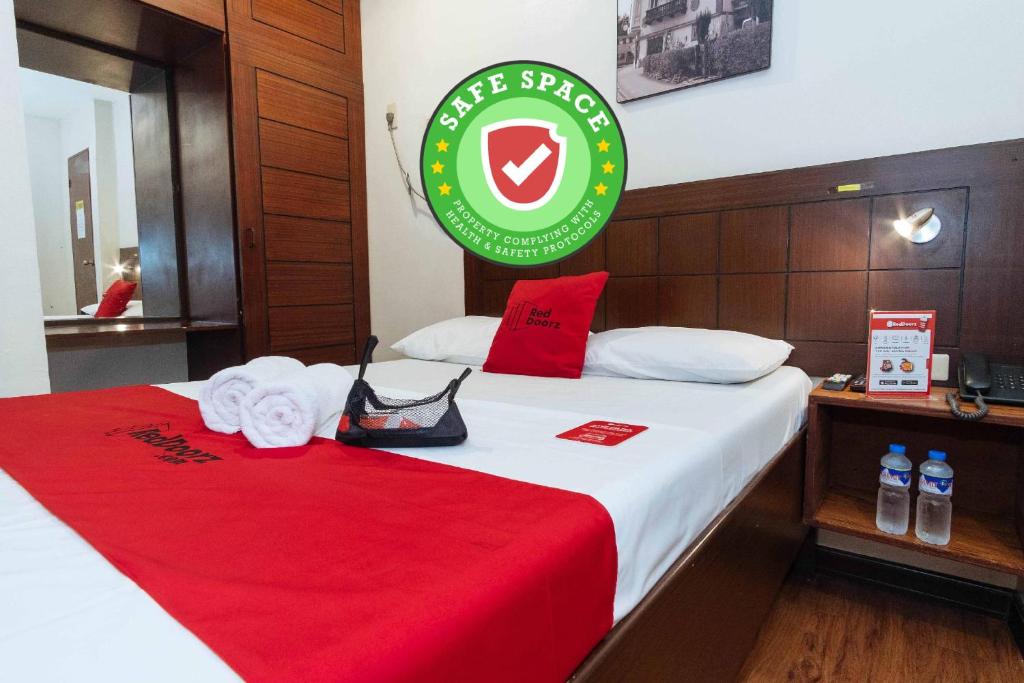 a hotel room with a bed with a red blanket at RedDoorz San Antonio Makati in Manila