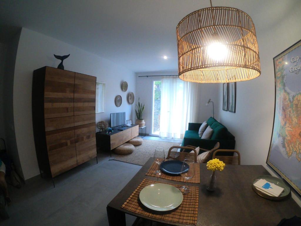 een woonkamer met een tafel en een kroonluchter bij Apartamento nuevo en el centro con garaje in Cadaqués