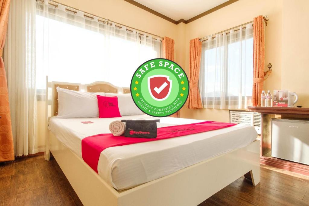 a bedroom with a large bed with a sign on it at RedDoorz Plus @ Seaborne Hotel Subic Zambales in Subic