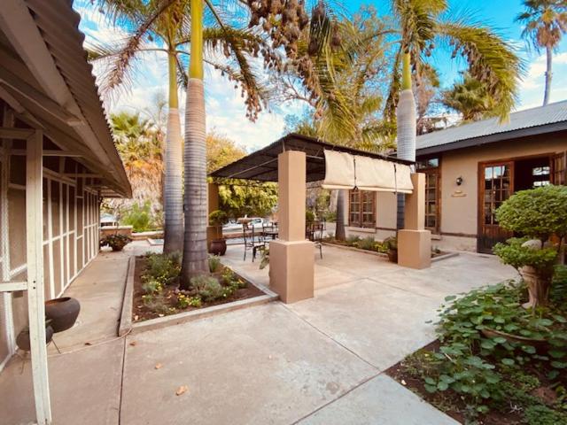 a house with palm trees and a patio with a table at Old Mine Guesthouse in Musina