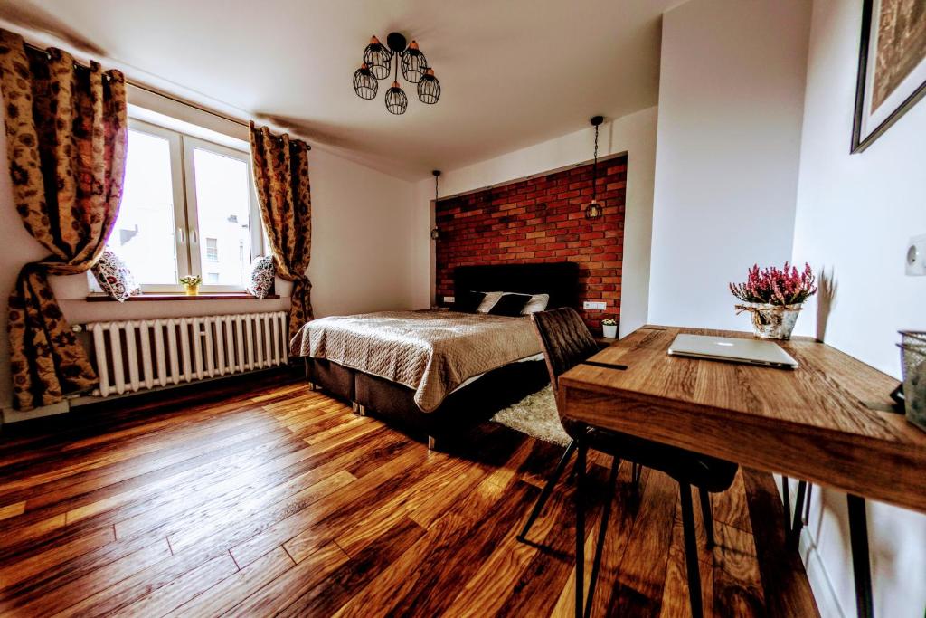 a bedroom with a bed and a desk and a table at Apartament Barbara in Gdańsk