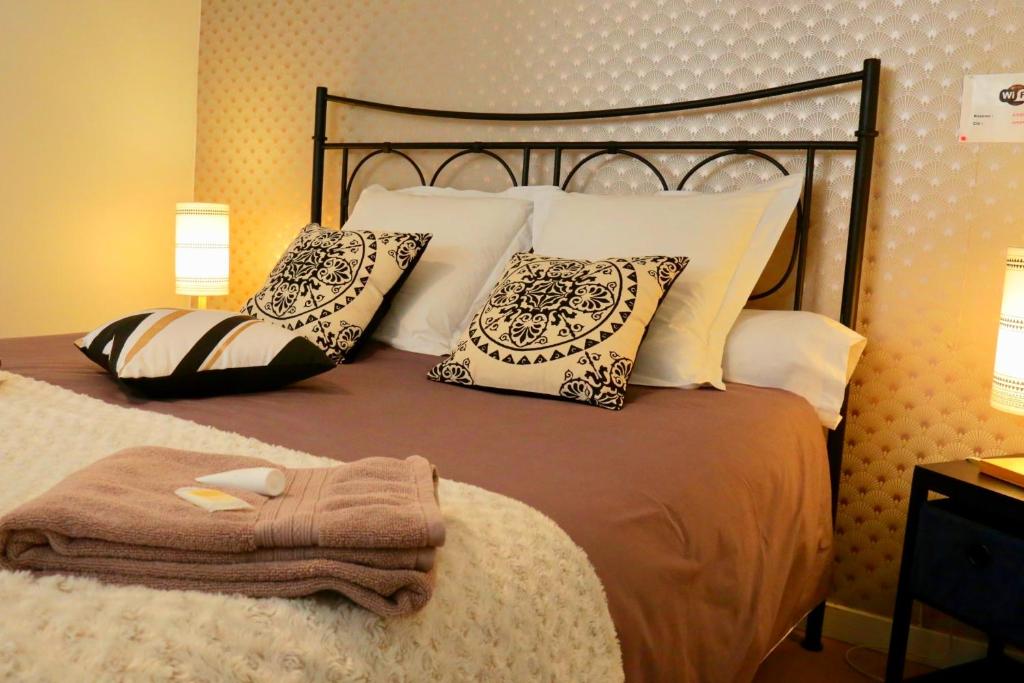 ein Schlafzimmer mit einem großen Bett mit Kissen in der Unterkunft Superbe appartement tout confort "Le Séquoia" in Monchy-Saint-Éloi