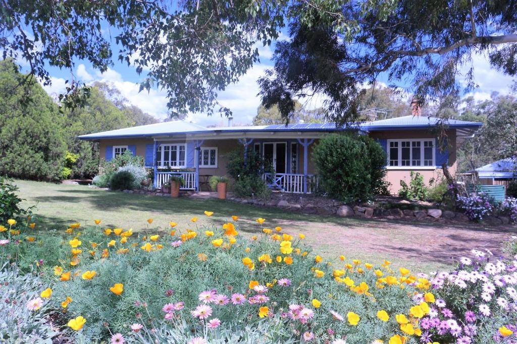 a house with a field of flowers in front of it at A Stanthorpe Getaway in Ballandean