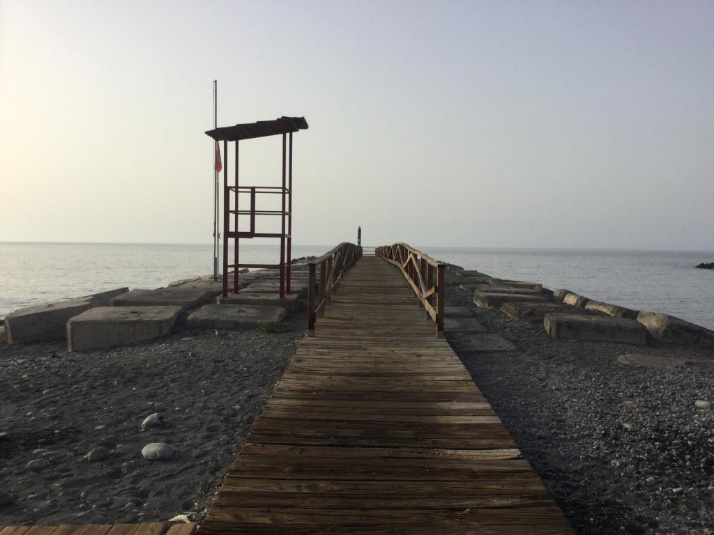 drewniana ścieżka prowadząca do oceanu z wieżą ratowników w obiekcie La Perla w mieście Playa de Santiago