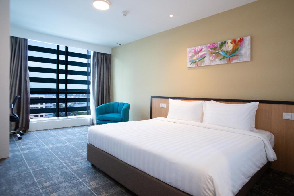 a hotel room with a large bed and a window at Hotel 7 Suria in Kota Kinabalu