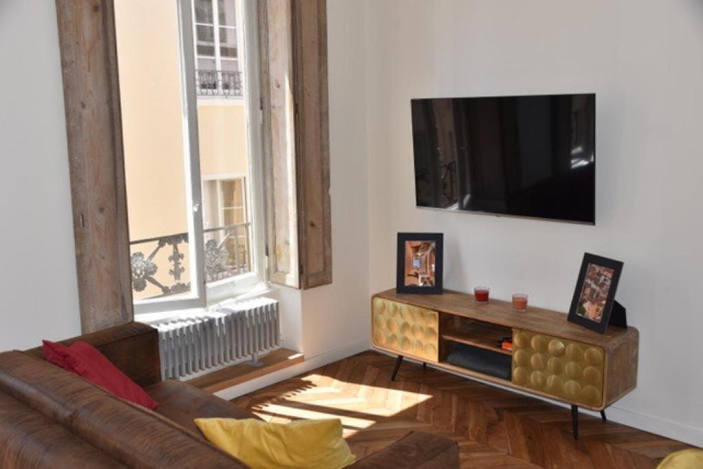 a living room with a couch and a flat screen tv at Appartement entier - refait à neuf - Loft - City Center in Lyon