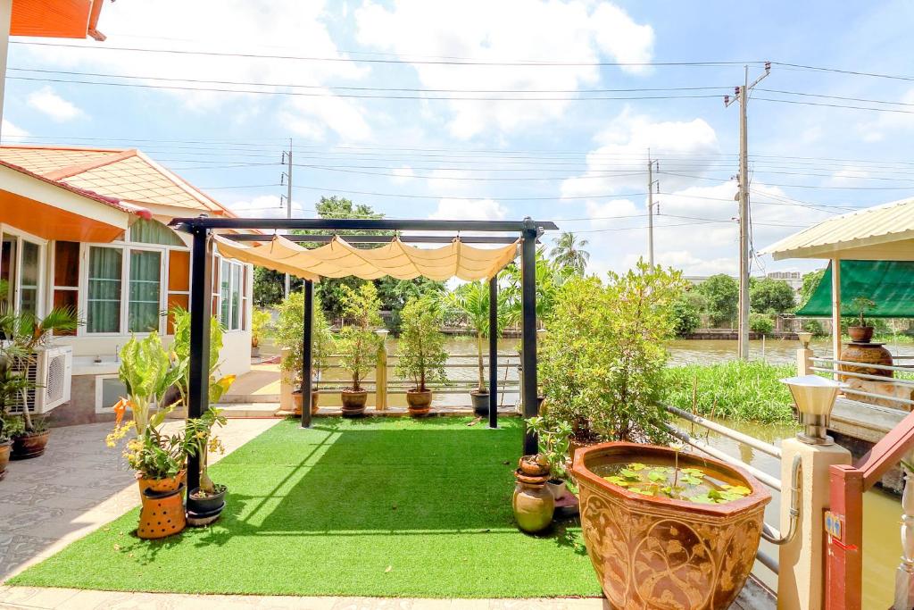 a backyard with a gazebo and green grass at OYO 750 Baan Suan Ampond in Bangkok
