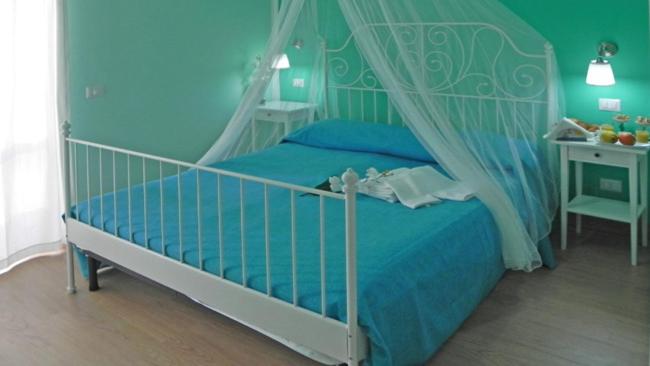 1 dormitorio azul con 1 cama con dosel en B&B Menen en Castellabate