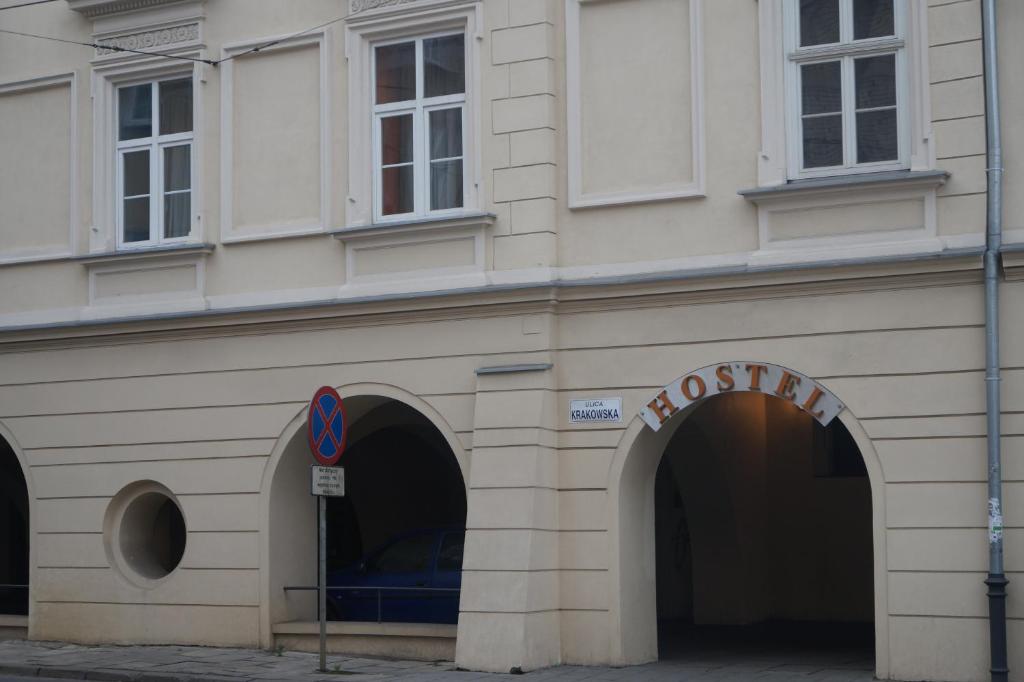 クラクフにあるKraków Hostelの二本のアーチと看板が立つ建物