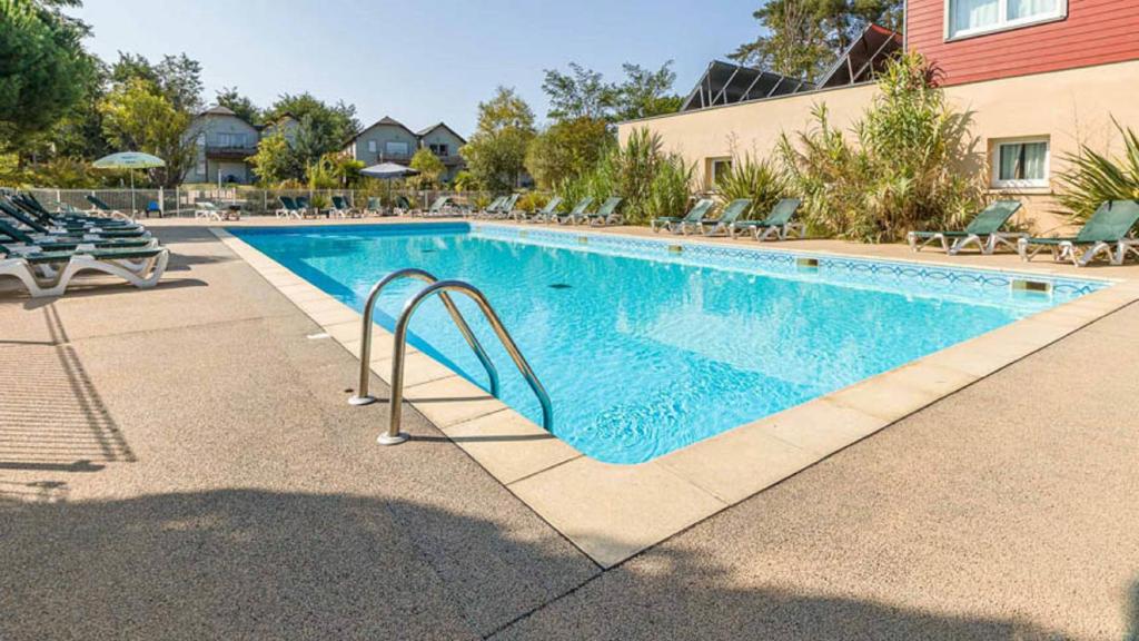 a swimming pool with a slide in a resort at Vacanceole - Relais du Plessis in Chaveignes