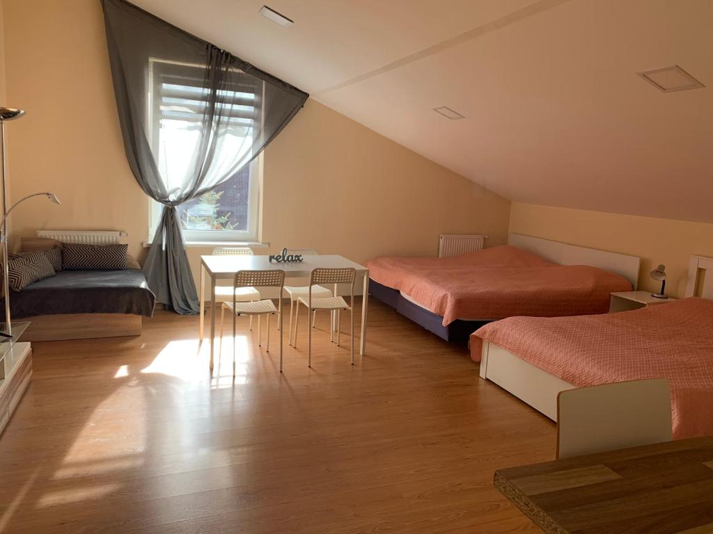 1 Schlafzimmer mit 2 Betten, einem Tisch und Stühlen in der Unterkunft Perla 12 butas in Birštonas