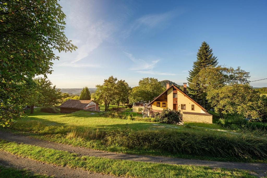 a house on a grassy field with a dirt road at Chalupa pod Ještědem in Světlá pod Ještědem