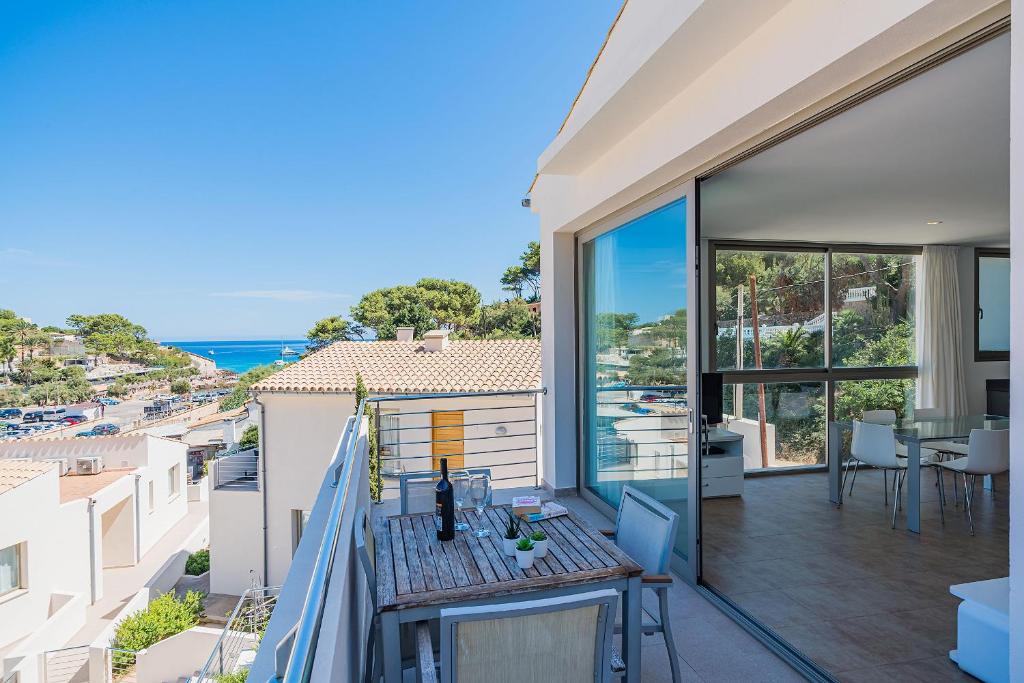 a balcony with a table and a view of the ocean at MOLINS 3 in Cala de Sant Vicenc