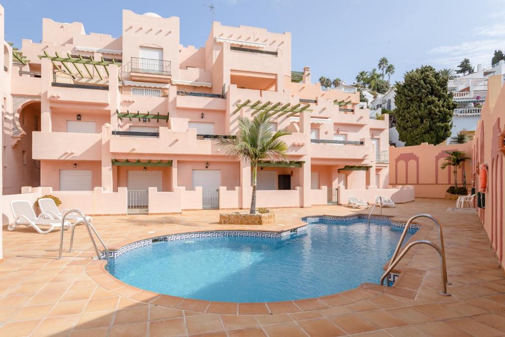 ein Hotel mit einem Swimmingpool vor einem Gebäude in der Unterkunft Apartamento Ibn Sadi8 in Nerja
