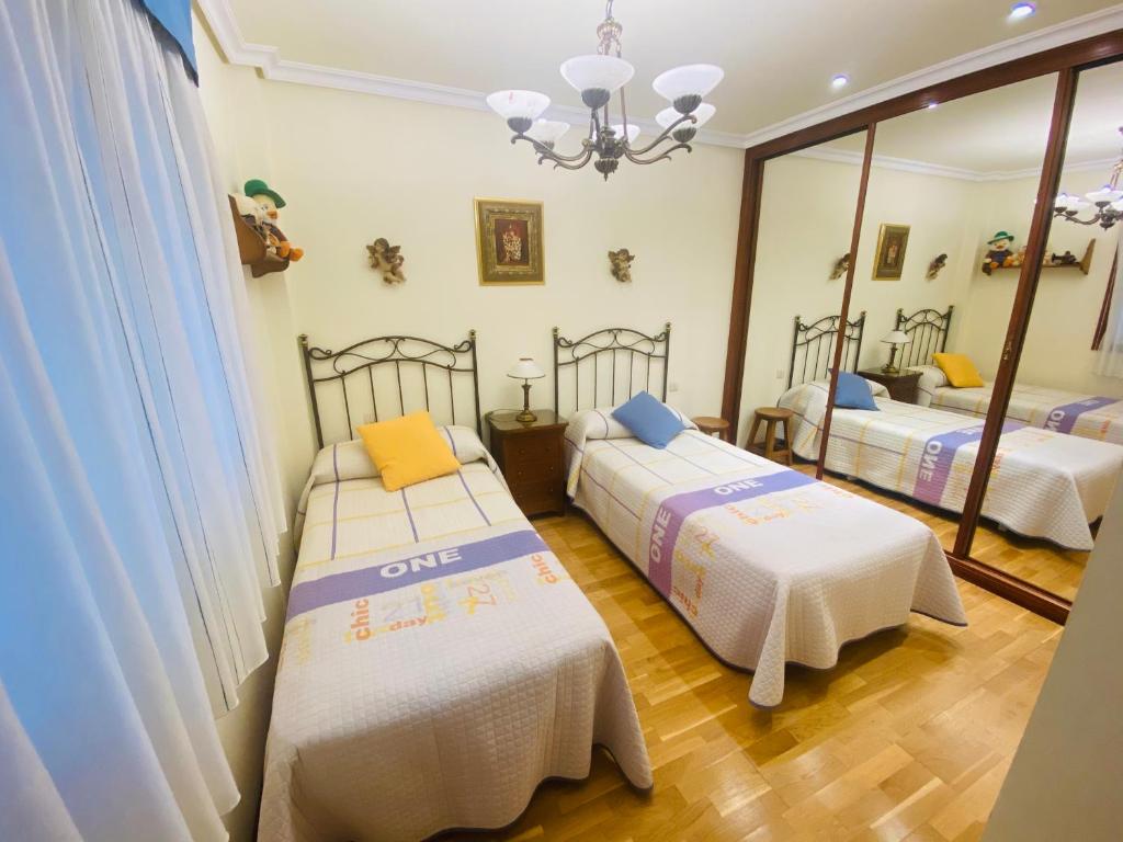 バイヨーナにあるPiso Céntrico Baionaのベッド2台と鏡が備わる客室です。
