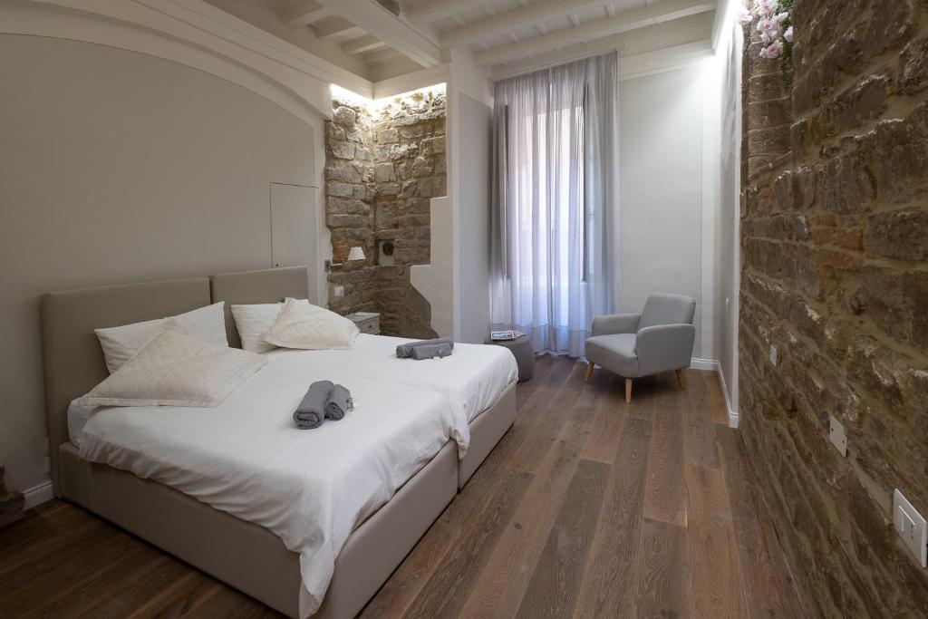 een slaapkamer met een groot bed en een stenen muur bij Casini’s house in Florence