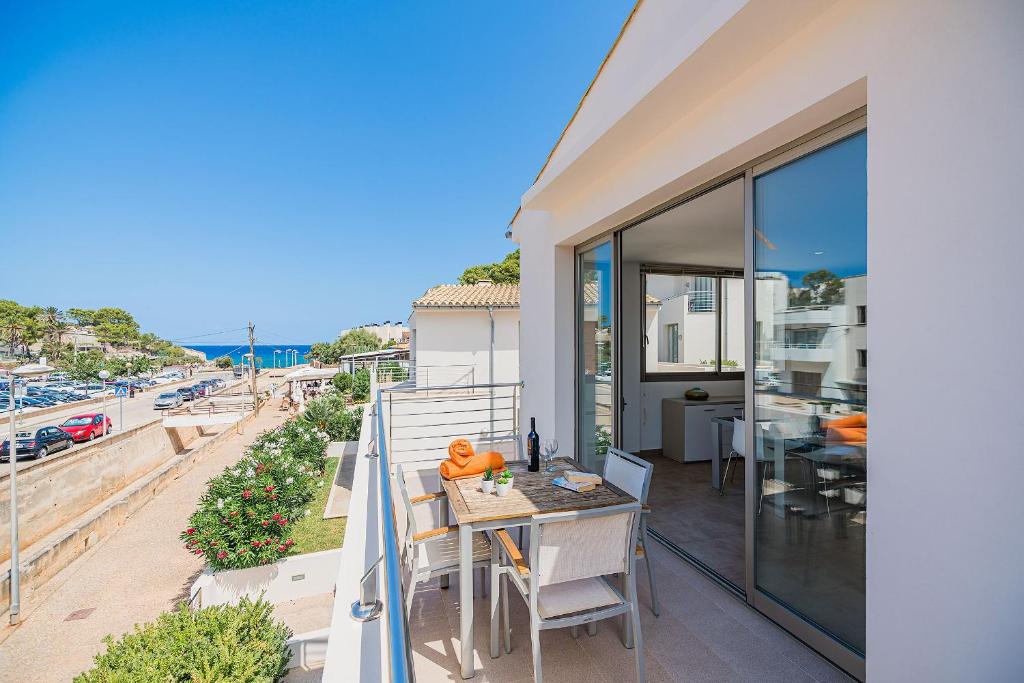 einen Balkon mit einem Tisch und Stühlen sowie Meerblick in der Unterkunft Molins 7 in Cala de Sant Vicent