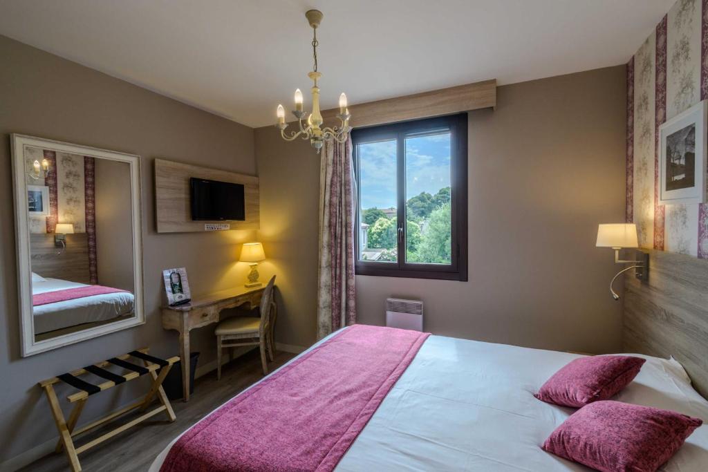 Postel nebo postele na pokoji v ubytování Hôtel l'Aragon