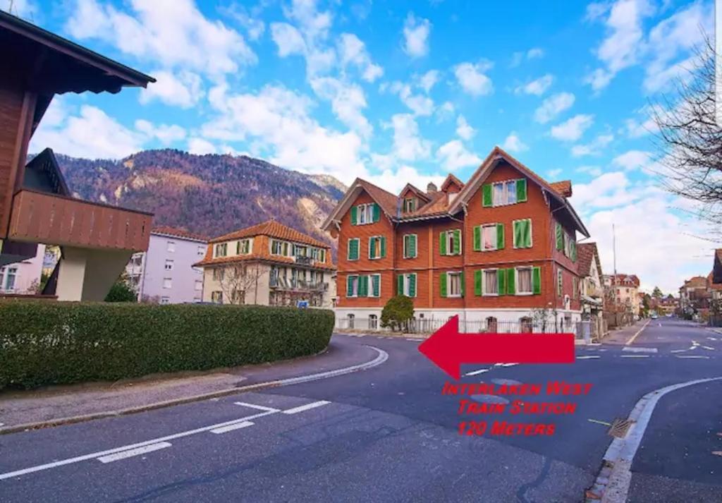 una imagen de una casa en una calle con una flecha roja en New West Station 7 en Interlaken