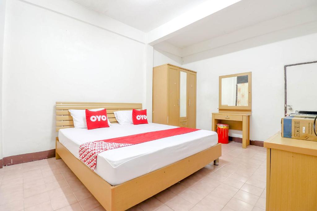 um quarto com uma cama com almofadas vermelhas em OYO 525 MRT Phetkasem 48-1 Place em Bangkok