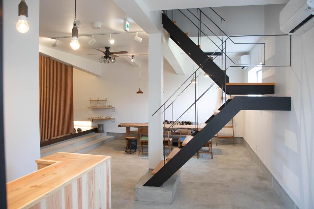 a staircase in a dining room with a table at 50歳以下限定'' チェックイン14-17時のみ可能 '' - 出雲大社 徒歩5分 - Hareilo sevens Hostel in Izumo