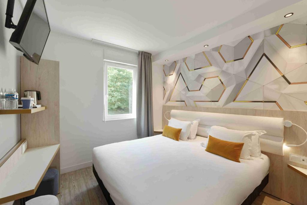 1 dormitorio con 1 cama blanca grande y TV en Kyriad Crepy En Valois en Crépy-en-Valois